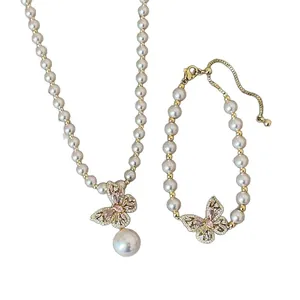 Elegantes Set aus rosa Perlenhalskette und Armband mit hohlem Schmetterlingsanhänger.