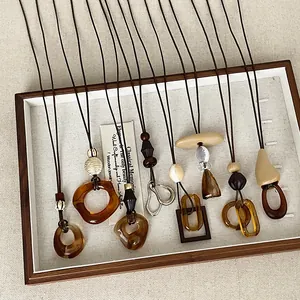 Vintage Maillard style amber resin geometric pendant necklaces displayed in a tray