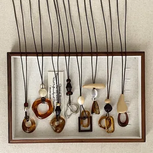 Variety of amber resin geometric pendant necklaces in Maillard style display