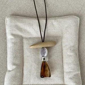 Detailed view of a retro geometric resin pendant necklace with amber Maillard style aesthetic