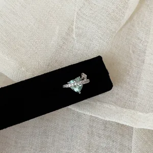Gros plan sur boucle d'oreille cœur zircon vert menthe avec étoile et détails argent