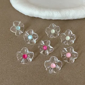 Vue détaillée des boucles d'oreilles fleurs plissées en résine avec cœurs colorés