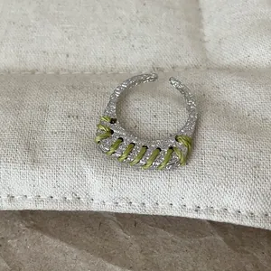 Nahaufnahme eines silbernen Rings mit grüner Fadenwicklung und Hammerschlag-Struktur.