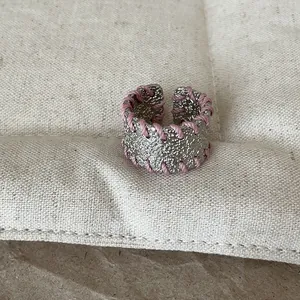 Detailaufnahme der einzigartigen Textur und der rosa Drahtwicklung am Metallringband