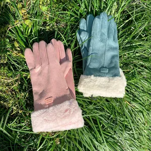 Pair of pink and blue suede winter gloves with plush faux fur cuffs on grass