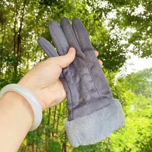 Detailed view of grey suede winter glove featuring a plush faux fur cuff and soft texture