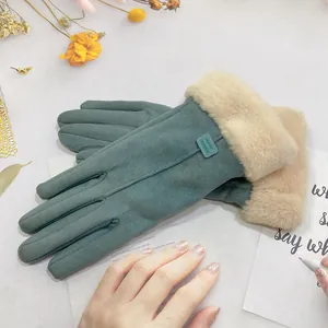 Close-up of women's teal suede winter gloves with plush beige faux fur cuffs