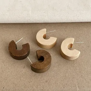 Macro view of vintage chunky wooden C-hoop earrings in dark and light finishes.