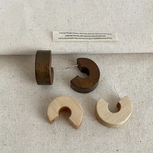 Detailed view of vintage wooden C-shaped hoop earrings in brown and beige tones.