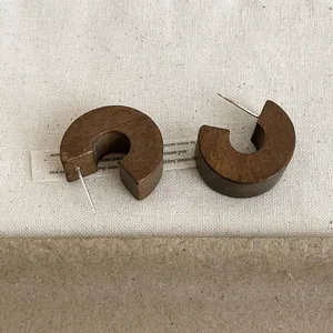 Detailed view of vintage wooden C-hoop stud earrings with natural brown texture