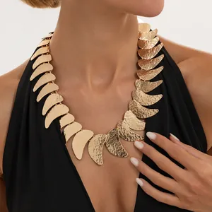 Primer plano de collar dorado con textura martillada y diseño de luna creciente