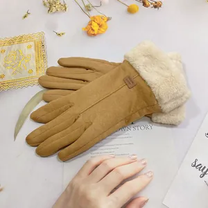 Macro view showing the soft suede texture and plush white fur cuffs of winter gloves.