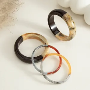 Primer plano de brazaletes de resina jaspeada retro con diseño elegante de bloques de colores