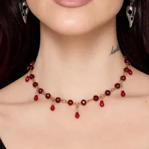 Close-up of retro dark style necklace with red crystal beads and waterdrop pendants.