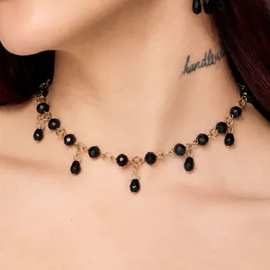 Close-up of gothic black crystal beaded necklace with teardrop tassels on neck