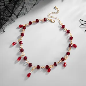 Detailed macro view of dark gothic red crystal bead necklace with teardrop tassels.