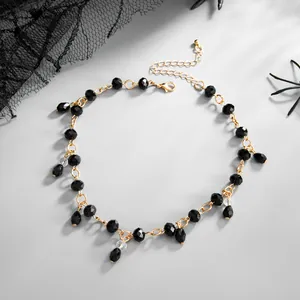 Gothic black beaded choker with golden chain and teardrop tassel pendants close-up