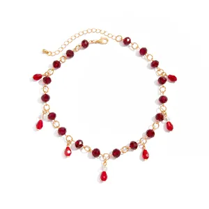 Detailed view of red faceted crystal beads and teardrop pendants on vintage gold chain