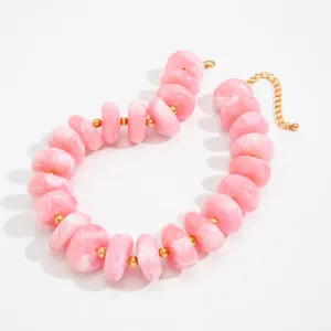 Nahaufnahme einer Halskette mit rosa marmorierten Harzperlen und goldenen CCB-Trennern