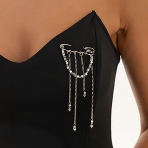 Vue détaillée d'une broche épingle à nourrice argentée hip-hop avec chaînes et perles.