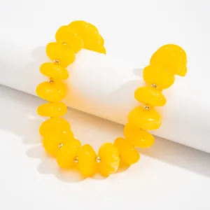 Detailansicht einer leuchtend gelben Harzperlenkette mit goldenen Trennperlen