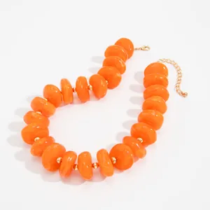 Detailansicht einer kräftigen orangefarbenen Harzperlenkette mit kleinen Goldperlen