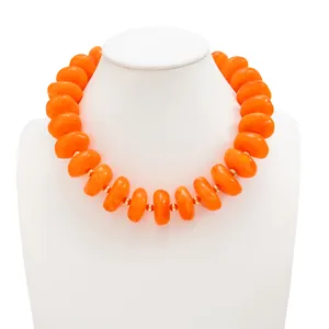 Auffällige orangefarbene Harzperlenkette mit goldenen Zwischenperlen auf weißem Display.