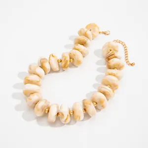 Detailansicht einer klobigen Marmor-Resin-Perlenkette mit goldenen Zwischenstücken.