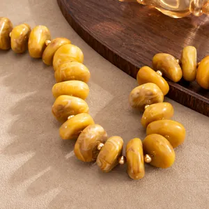 Hochwertiges Makro-Detail einer bernsteinfarbenen Harzkette mit Gold-Abstandhaltern