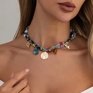 Close-up of bohemian silk scarf choker with leaf and resin bead charms on model.