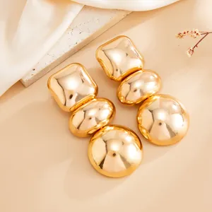 Detailed view of gold geometric mirror stud earrings with high-gloss finish.