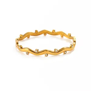 Vue macro détaillée d'un bracelet jonc ondulé en acier inoxydable doré avec zircons