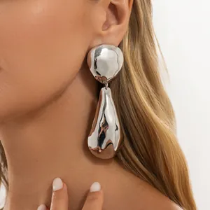 Detail of oversized silver waterdrop earrings with a highly polished mirror finish.