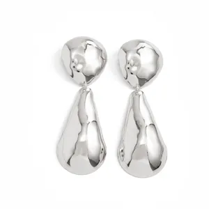 Close-up of exaggerated waterdrop geometric earrings with a polished mirror finish