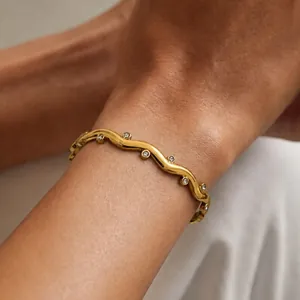 Vue détaillée d'un bracelet vague plaqué or 18 carats avec cristaux scintillants