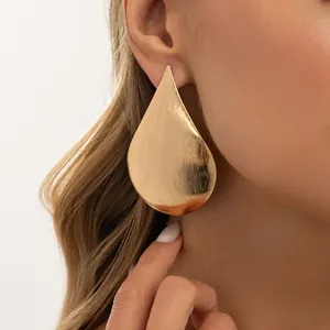 Detailed view of the brushed gold surface on this oversized teardrop stud earring