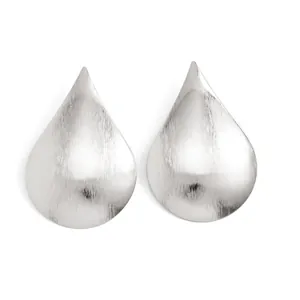Close-up detail of silver teardrop stud earrings featuring a brushed metallic finish