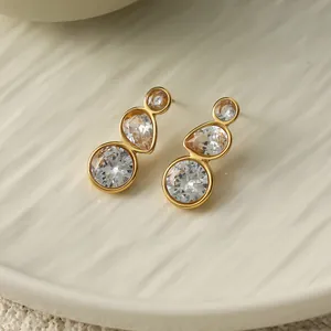 Detailansicht goldener Edelstahlohrstecker mit funkelnden, klaren Zirkonia-Elementen.