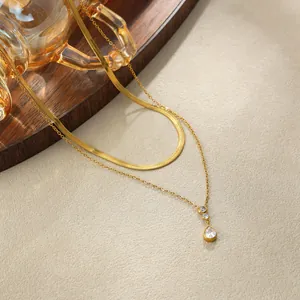 Dettaglio della collana dorata a due strati con pendente a goccia in zircone e catena a serpente