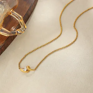 Gros plan d'un collier en acier inoxydable doré avec pendentif en zircone en forme de larme.