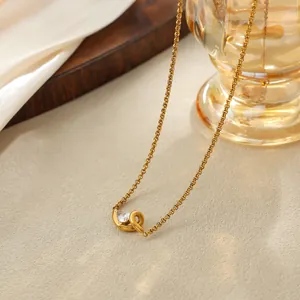 Vue détaillée d'un collier en acier inoxydable doré avec pendentif goutte en zircon cubique.
