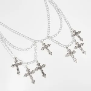 Detailed view of a gothic layered silver body chain with several ornate cross pendants
