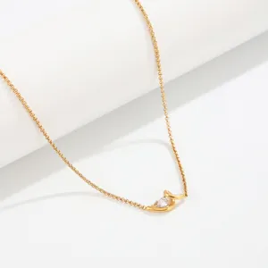 Gros plan d'un collier en acier inoxydable doré avec pendentif goutte d'eau en zircon