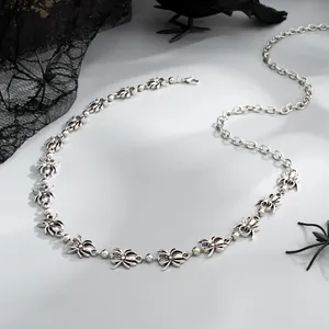 Detail view of a silver gothic spider body chain featuring intricate metal links.