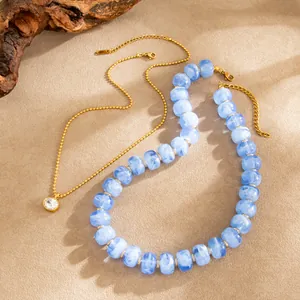 Detailaufnahme von blau marmorierter Harzkette und goldener Zirkonia-Edelstahlkette