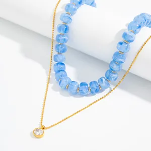Detailansicht der eisblauen Marmor-Harzperlenkette mit goldenem Zirkon-Anhänger aus Edelstahl