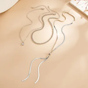 Vue détaillée élégante d'un collier argenté à plusieurs rangs avec chaîne serpent et pompons