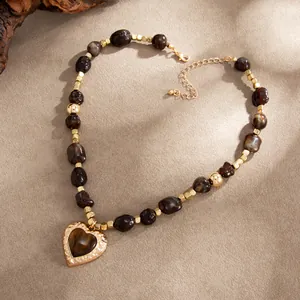 Macro-opname van een vintage barnsteenkleurige harskralen ketting met hart hanger