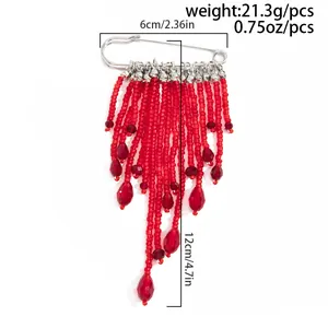 Vue détaillée de la broche à glands en perles rouges et cristal avec dimensions et poids.