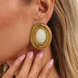 Dettaglio di orecchini ovali vintage placcati in oro 18K con inserto in resina marmo
